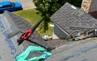Roofing materials and tools on house roof.