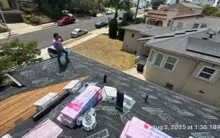 Rooftop construction with supplies and worker on smartphone.