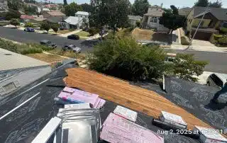 Rooftop view with roofing materials and neighborhood street.