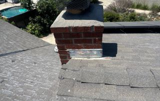 Brick chimney on rooftop, residential neighborhood view.