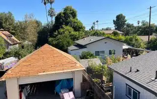 Suburban backyard view with garage and lush trees.