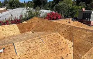 Newly constructed wooden roof under blue sky.