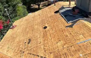 Plywood roof deck under construction, sunny day view.