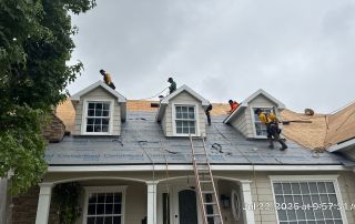 Workers installing new roof on house