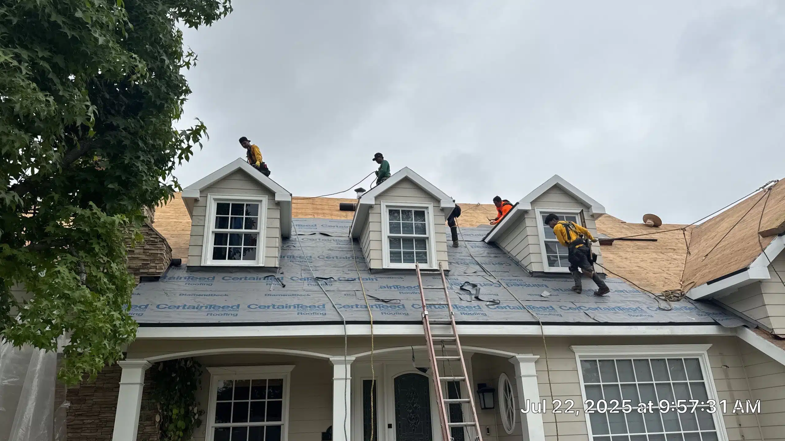 Workers installing new roof on house