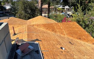 Unfinished wooden roof under construction with trees nearby.