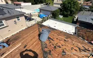 Rooftop renovation with worker and tools.