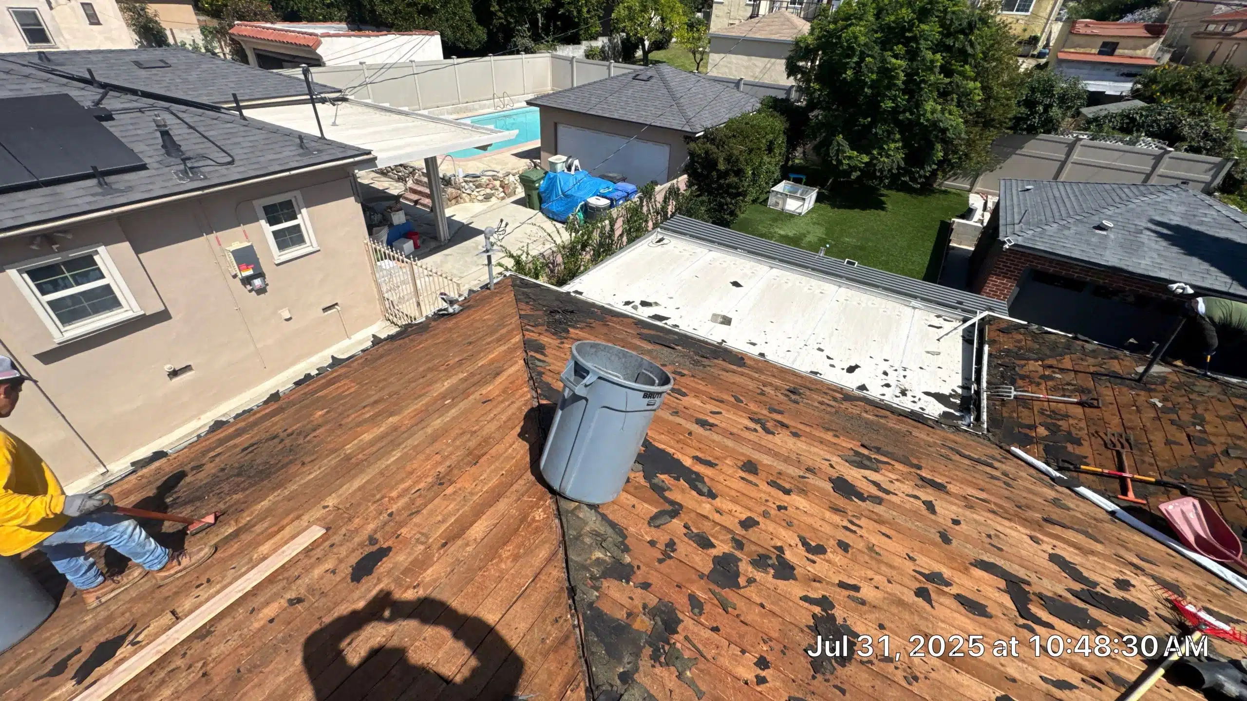 Rooftop renovation with worker and tools.