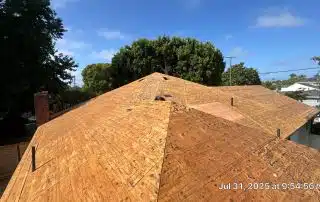 Wooden roof under construction with trees nearby.