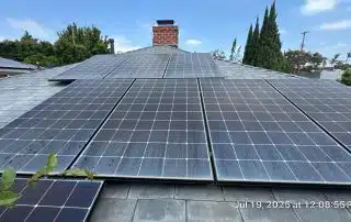 Solar panels on residential roof under blue sky.