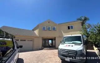 House exterior with trucks on driveway.