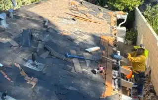 Workers repairing roof under clear sky