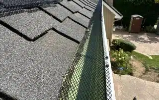 Gutter guard installation on shingle roof.