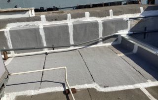 Rooftop with waterproofing sealant and pipes visible