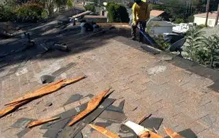 Rooftop repair with scattered shingles and debris