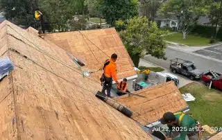 Workers repairing rooftop on residential street.