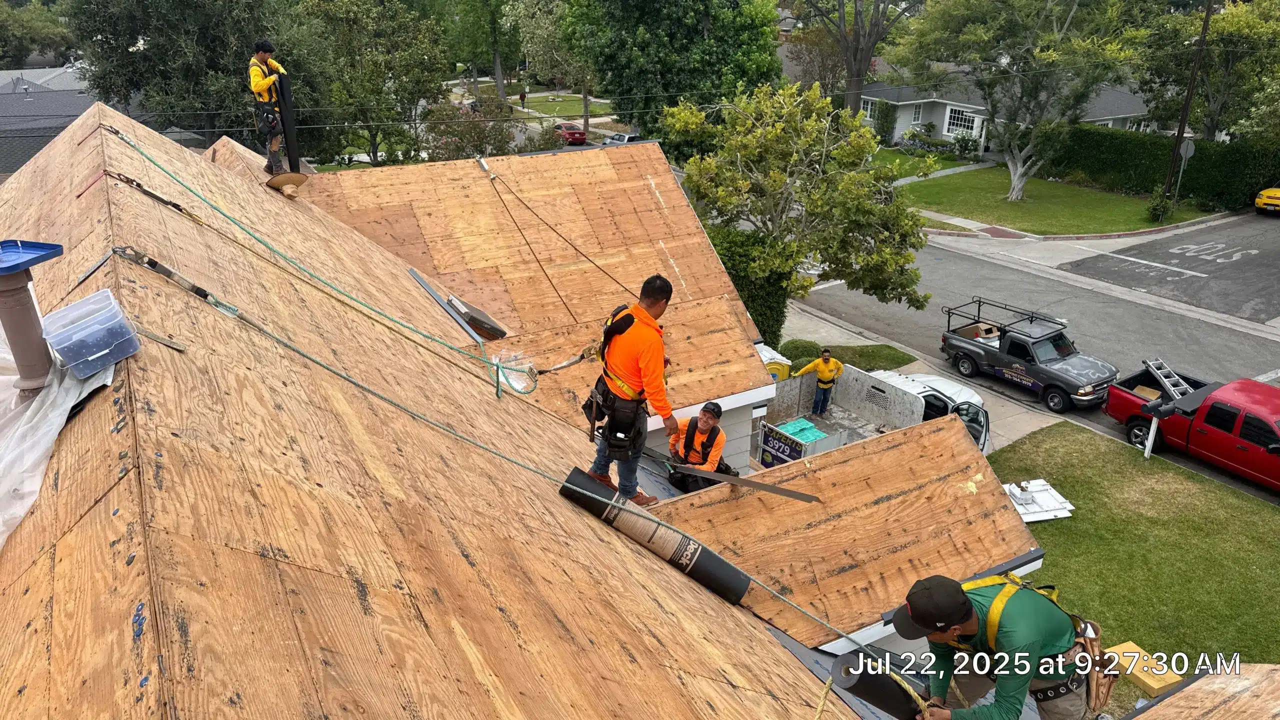 Workers repairing rooftop on residential street.