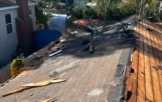 Roof repair work in progress on sunny day.