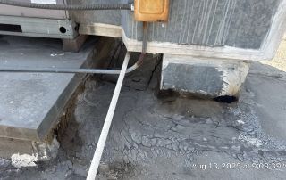Cracked concrete around rooftop HVAC unit.