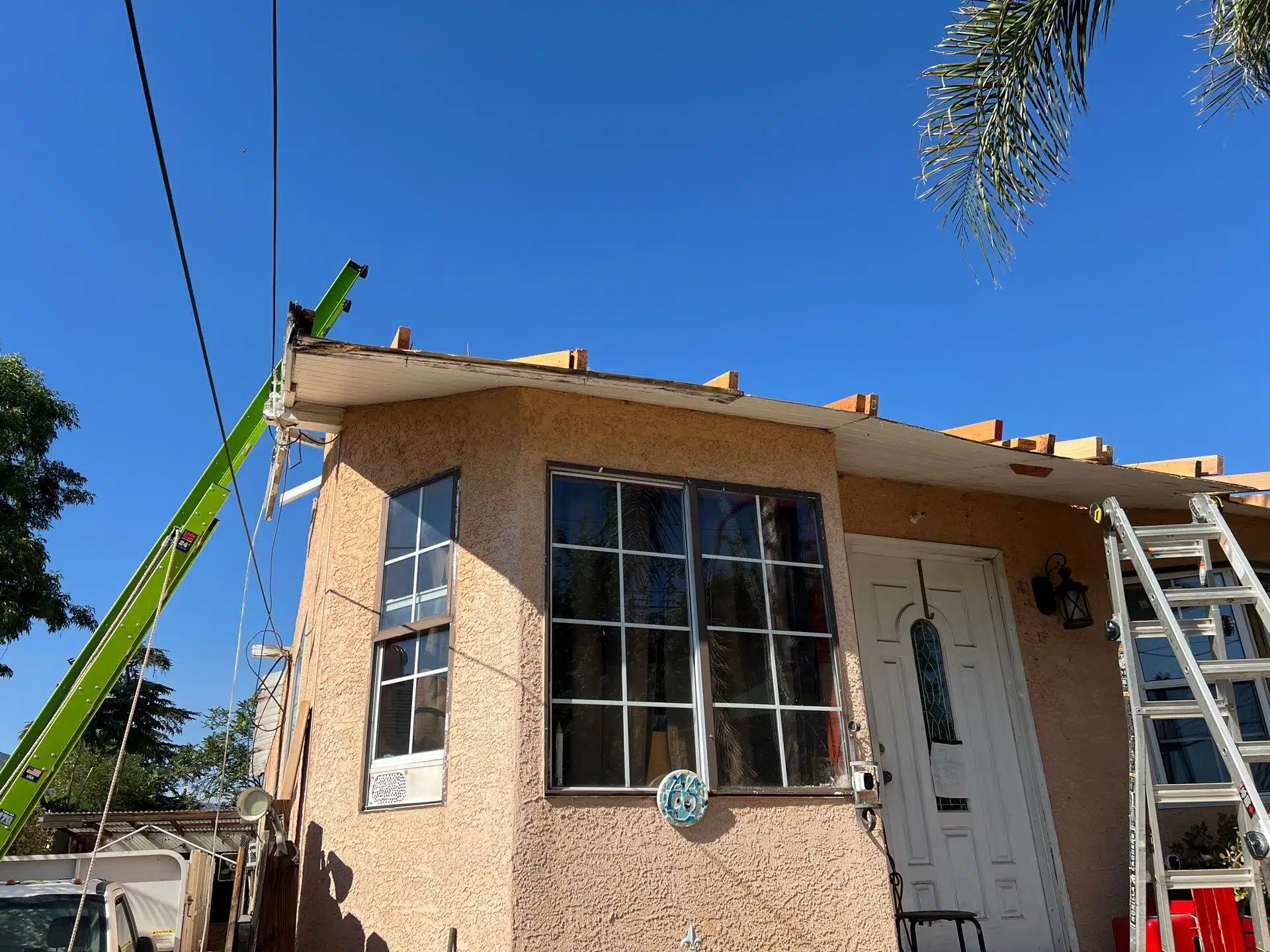 House roof under construction with ladder and crane.