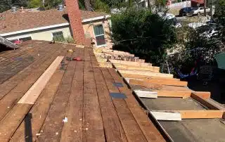Roof under construction with wooden beams and tools.