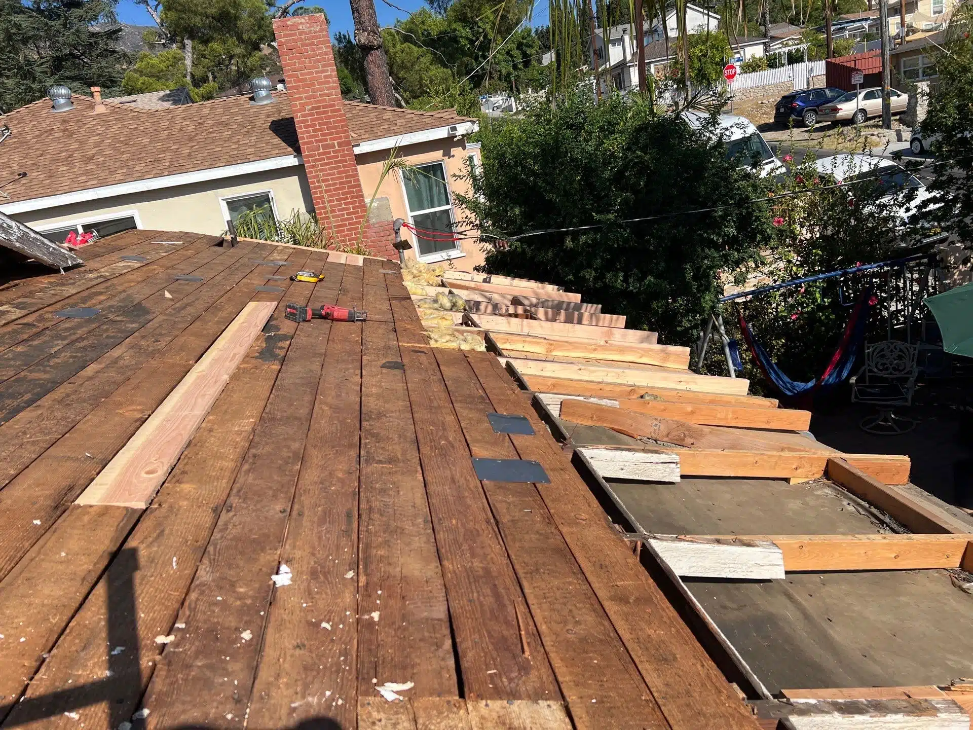 Roof under construction with wooden beams and tools.