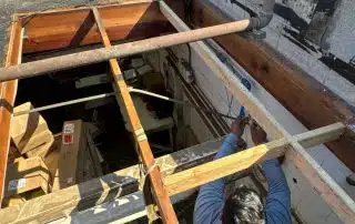4-Aug 22 2025 04_04pm-YX46 Worker repairing rooftop structure in bright sunlight.
