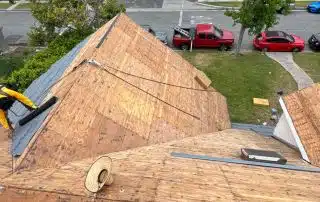 Worker installing materials on wooden rooftop.