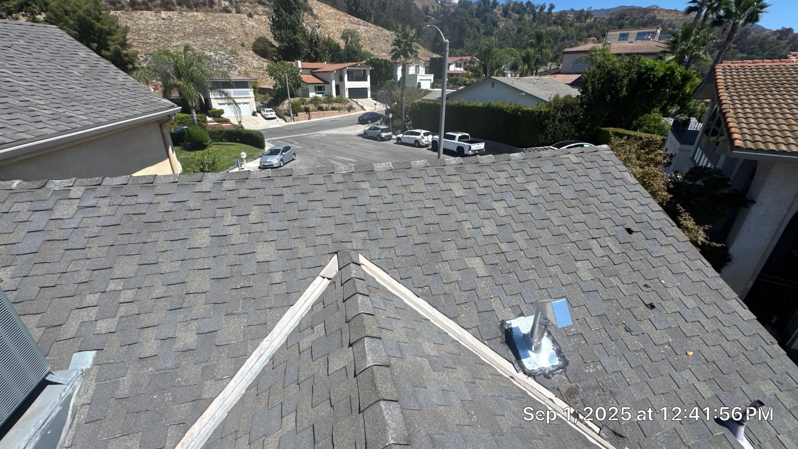 Suburban street view from rooftop, sunny day.
