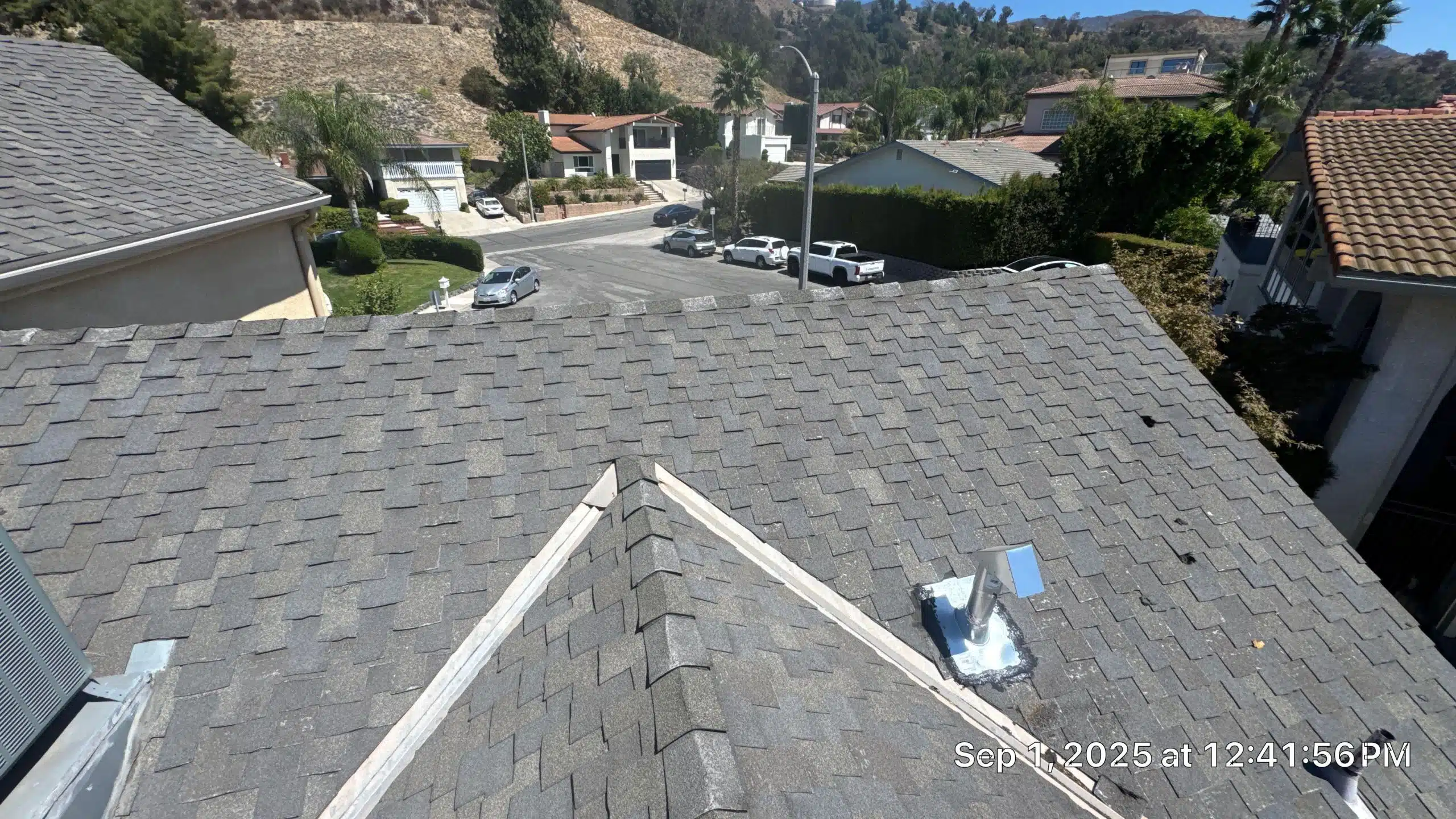 Suburban street view from rooftop, sunny day.