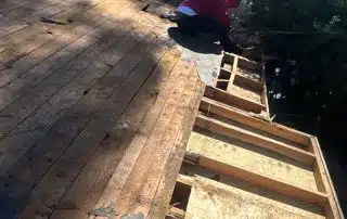 Worker repairing wooden roof under sunlight.