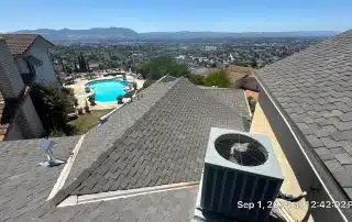 Rooftop view of suburban pool and cityscape.
