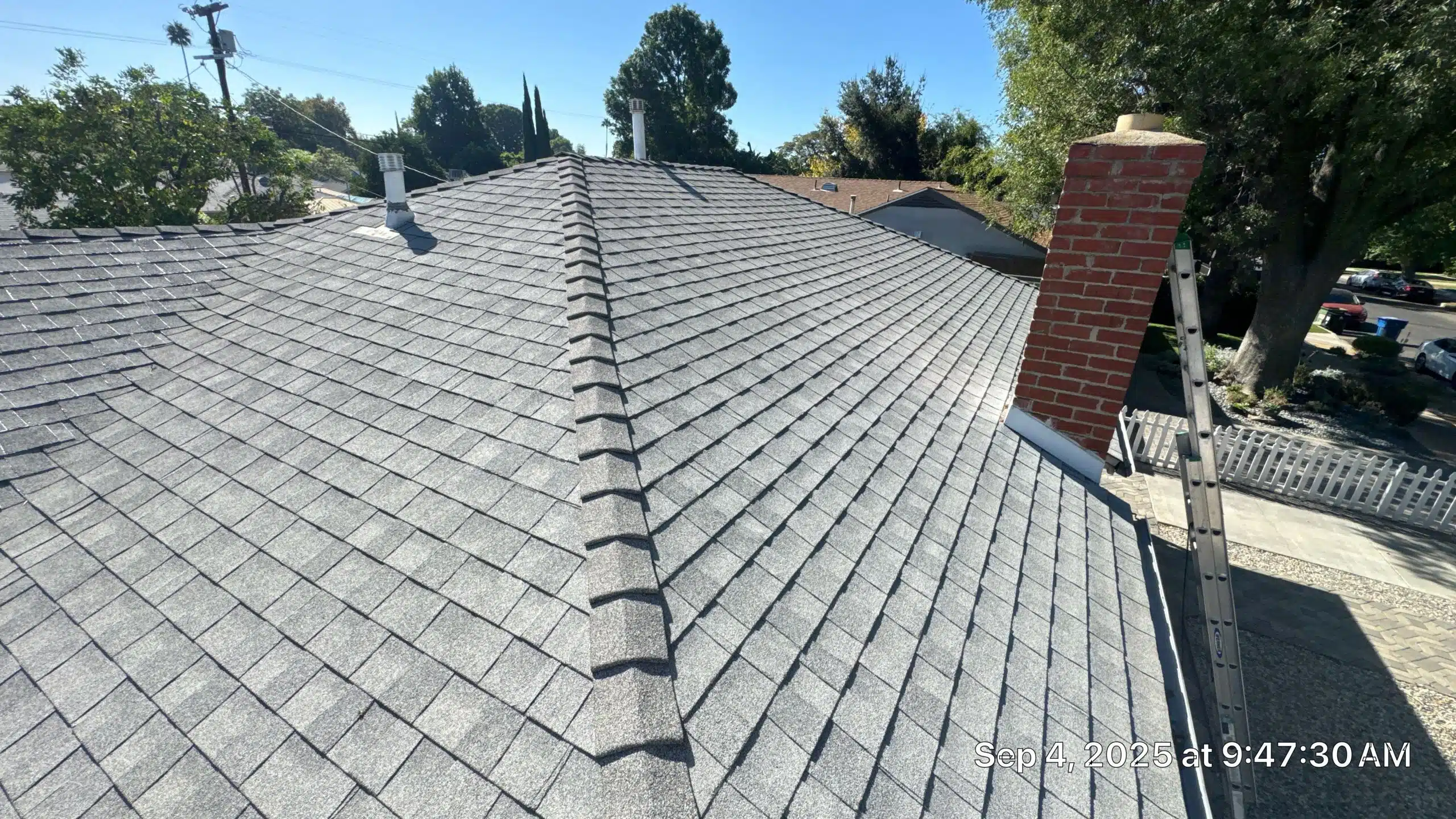 Asphalt shingle roof with chimney and ladder