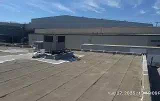 8-Aug 27 2025 03_19pm-oyKq Industrial rooftop with HVAC unit and clear sky.