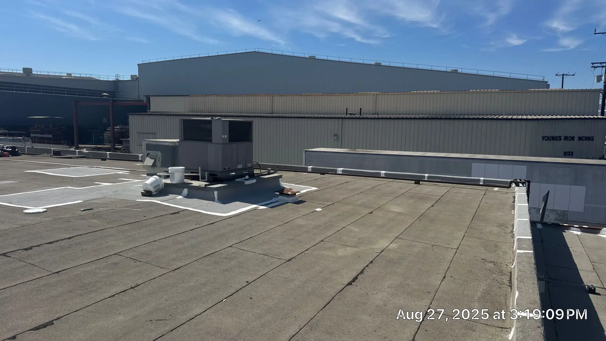 Industrial rooftop with HVAC unit and clear sky.