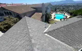 Rooftop view with pool and mountains.