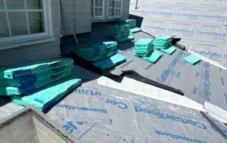 Roof under construction with building materials stacked.