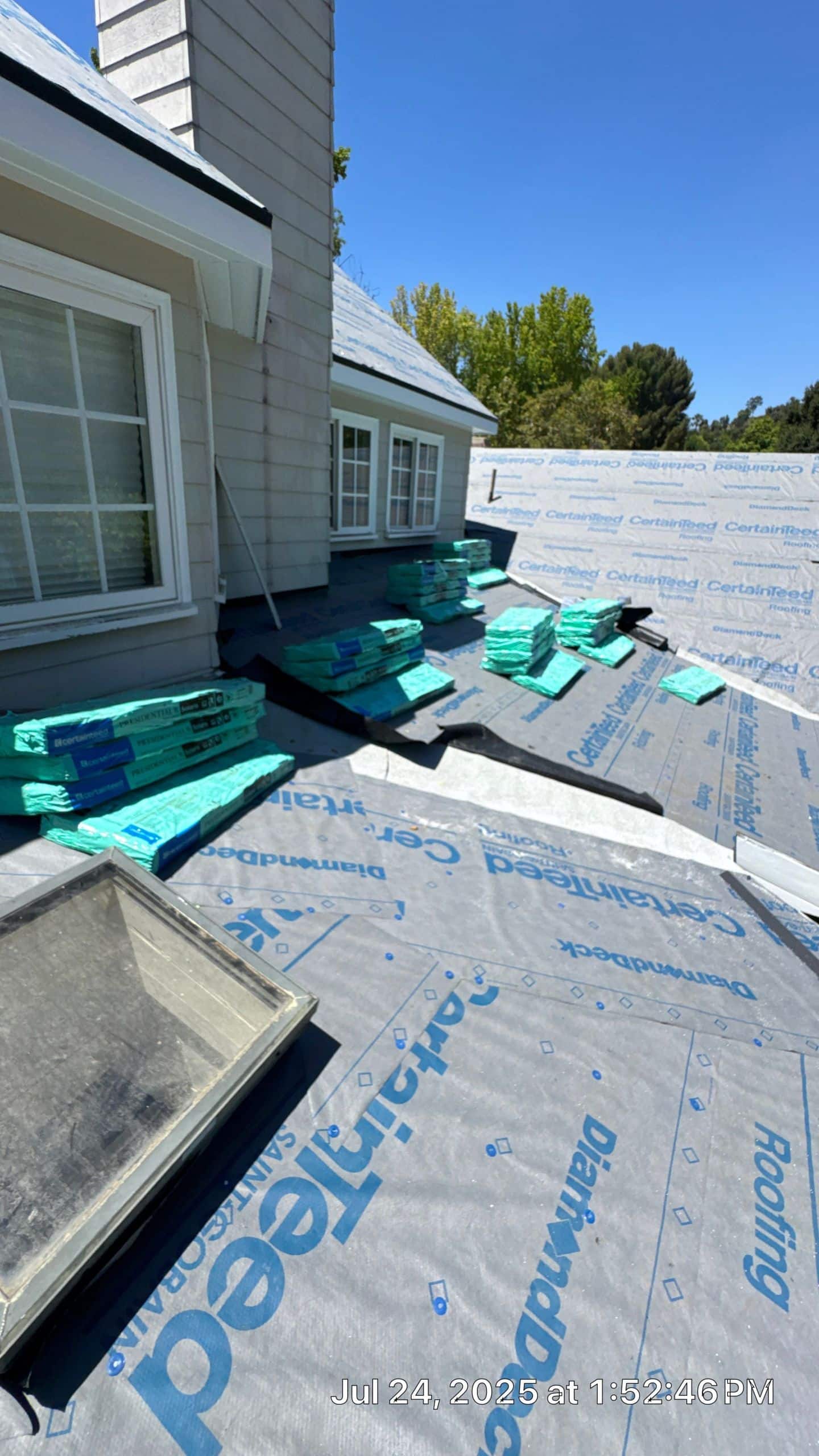 Roof under construction with building materials stacked.