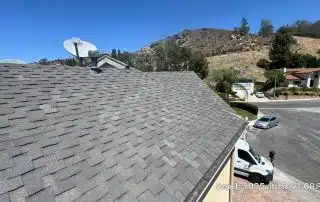 Asphalt shingle roof with satellite dishes, clear sky.