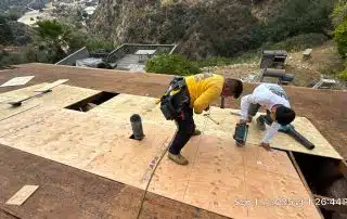 1-Sep 11 2025 01_26pm-ynFa Workers repairing roof with plywood in mountainous area.