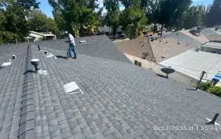 Person inspecting rooftop on a sunny day.