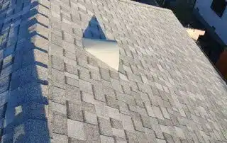 Asphalt roof with missing shingles, needs repair.