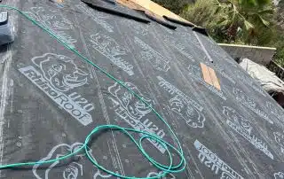 12-Sep 12 2025 10_46am-BgGc Roofing underlayment installation near brick chimney.