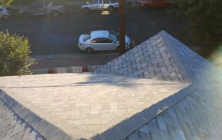 View of street from rooftop with shingles