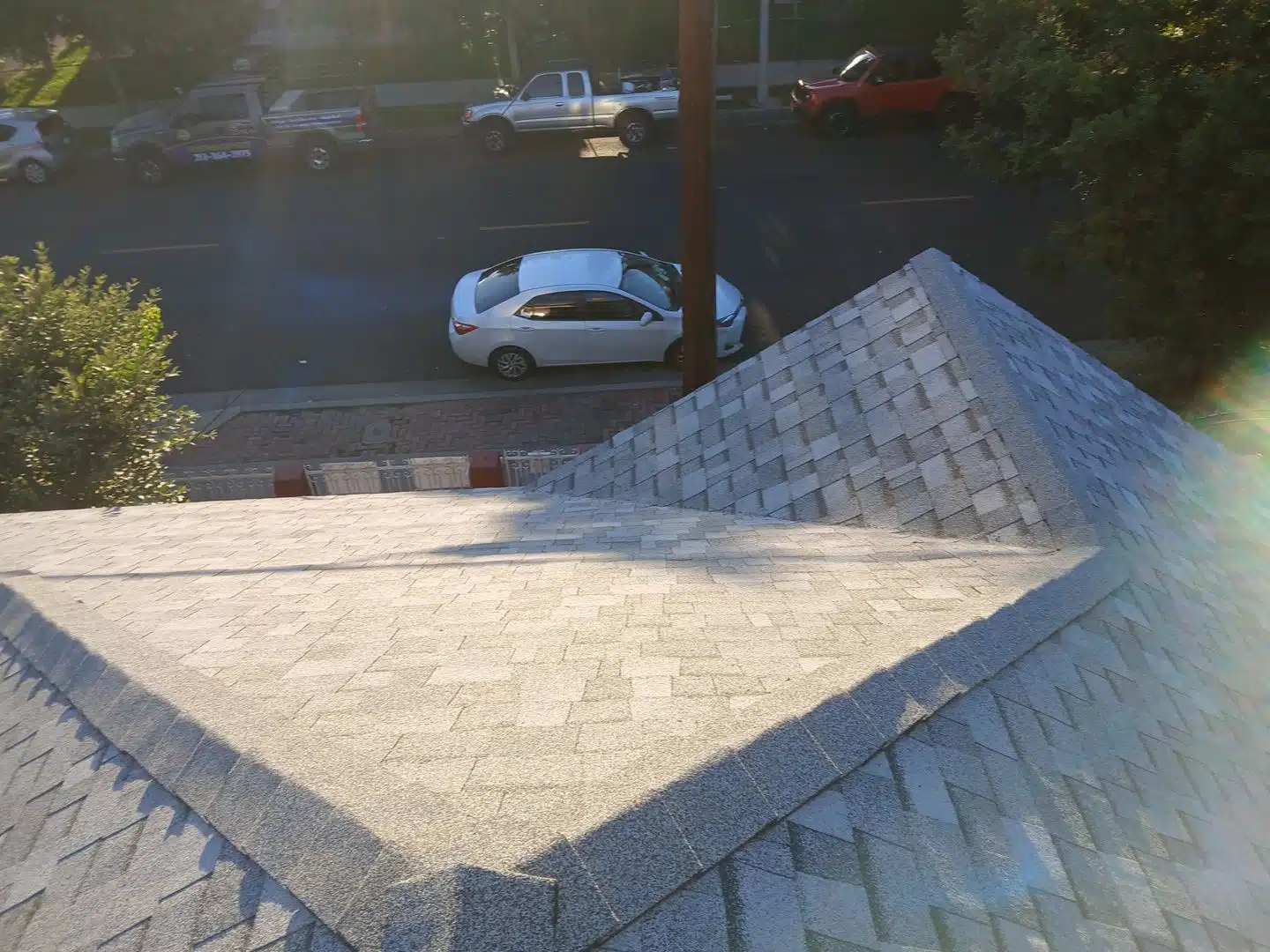 View of street from rooftop with shingles