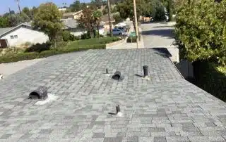 Roof with shingles and vents in suburban area.
