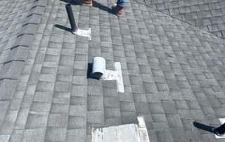 Person walking on shingled roof with vents.
