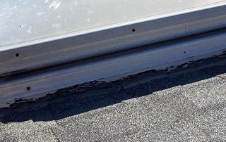 Damaged roof flashing on a shingled roof