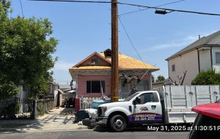 House under renovation with roofing truck nearby.