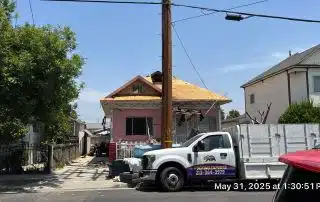House under renovation with roofing truck nearby.